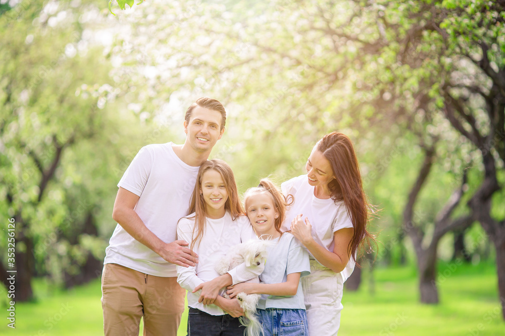 Adorable family in blooming cherry garden on beautiful spring day Adorable family in blooming cherry garden on beautiful spring day