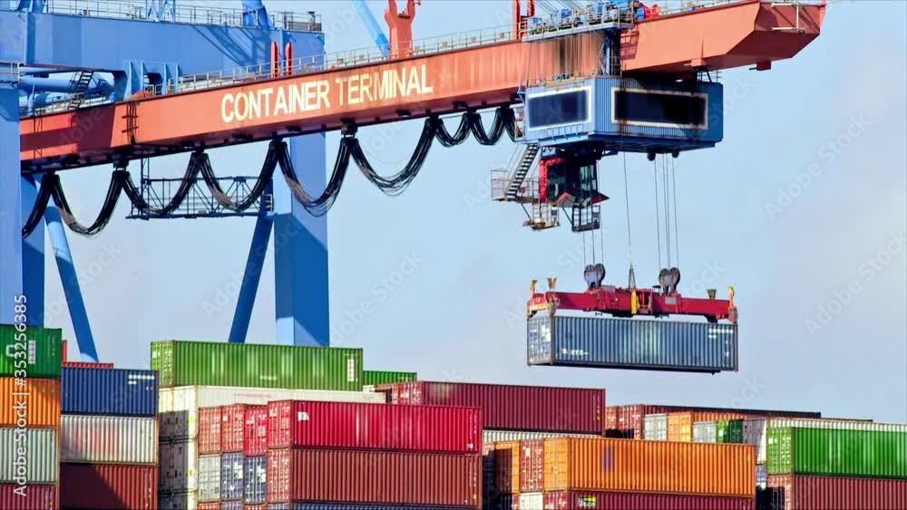 Gantry crane is unloading a container from a ship at daytime in the port of Hamburg / Germany