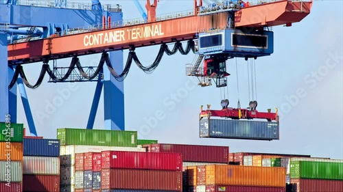 Gantry crane is unloading a container from a ship at daytime in the port of Hamburg / Germany photo