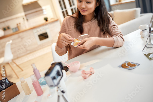 Find your true space. Cropped shot of young female blogger recording a tutorial video for her beauty blog about skincare routine. Vlogger testing eye patch, recording video for social network