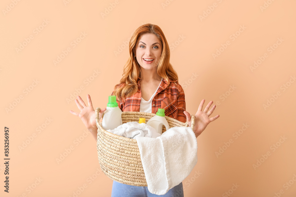 Beautiful woman with clean laundry and detergents on color background Beautiful woman with clean laundry and detergents on color background
