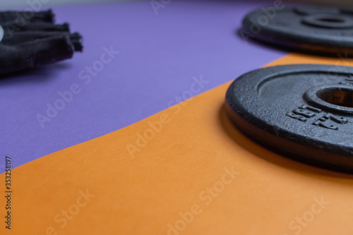Fitness equipment on a purple and orange background with copy sp
