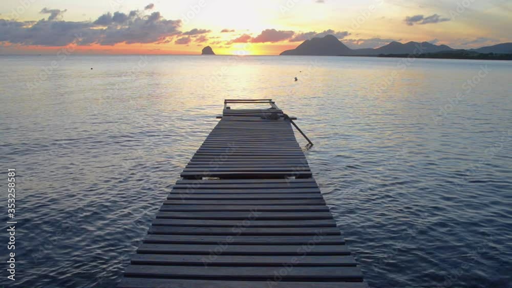 couché du soleil sur un ponton de bois au milieu d'un baie de Martinique