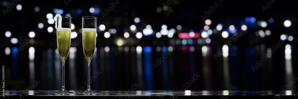 A pair of sparkling wine glasses placed on a marble table over a night view. 3D rendering.