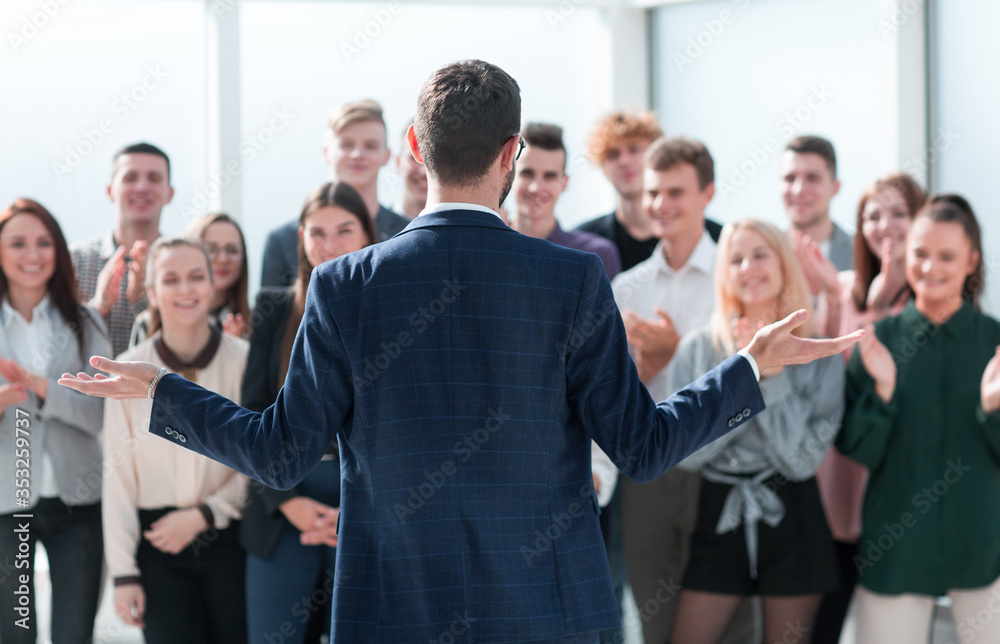 rear view. the project Manager welcomes his business team rear view. the project Manager welcomes his business team
