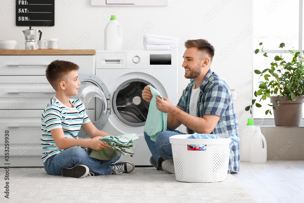 Man and his little son doing laundry at home Man and his little son doing laundry at home