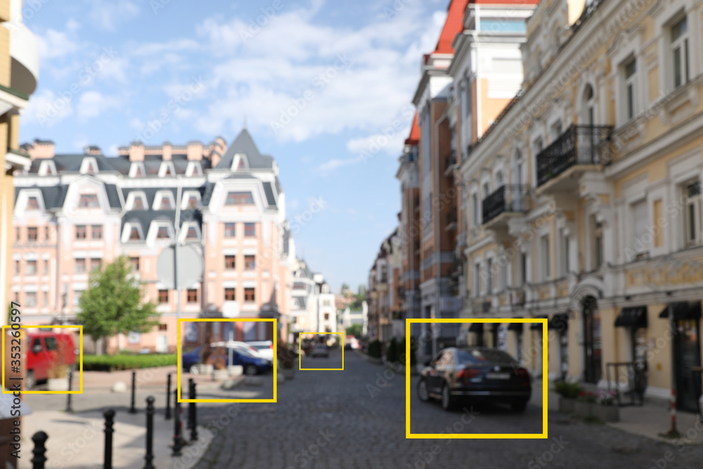 Blurred view of buildings and street with scanner frames on cars in city. Machine learning