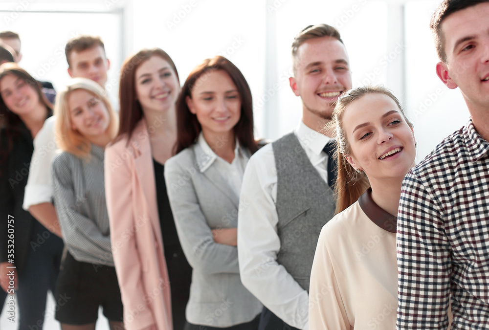 group of smiling young professionals standing in a row. group of smiling young professionals standing in a row.
