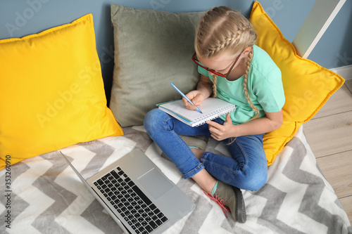Cute little girl studying a...