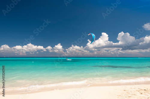 Obraz na plátně Kitesurfer Caucasian man with Kiteboard in front of an amazing and deserted trop