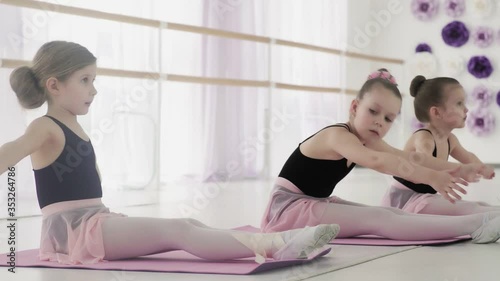 Young ballerinas training their flexibility.