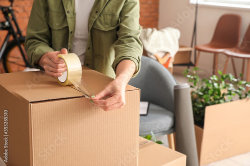 Woman packing moving box at home photo