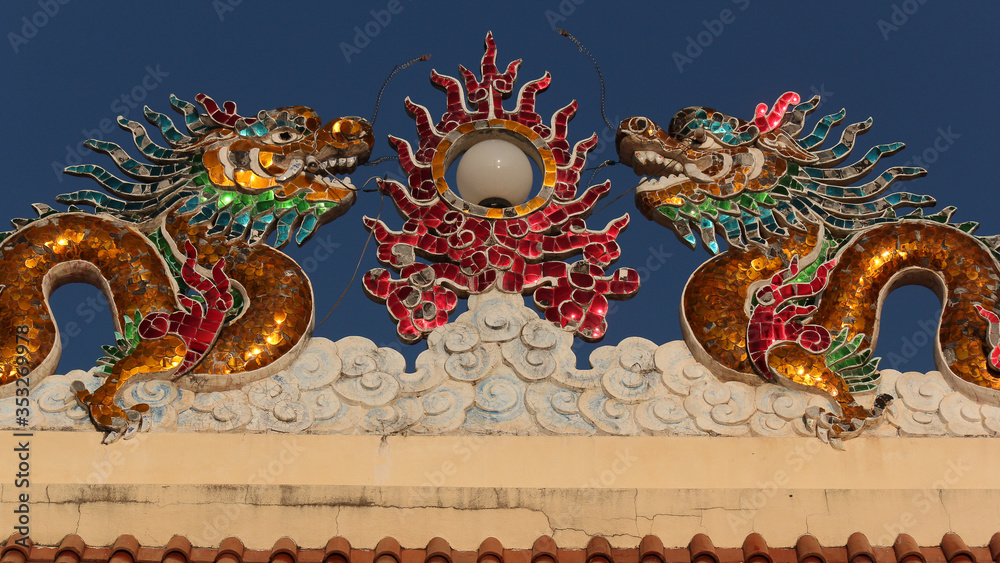 Naklejka premium glass mosaic dragon image as roof top decoration in a chinese temple in the city of savannakhet lao PDR
