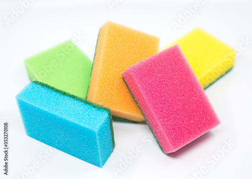 colorful sponges for washing dishes scattered around on a white background