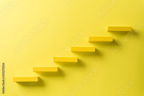 Concept of building success foundation. Red wooden block stacking as step stair, Success in business growth concept on black background.