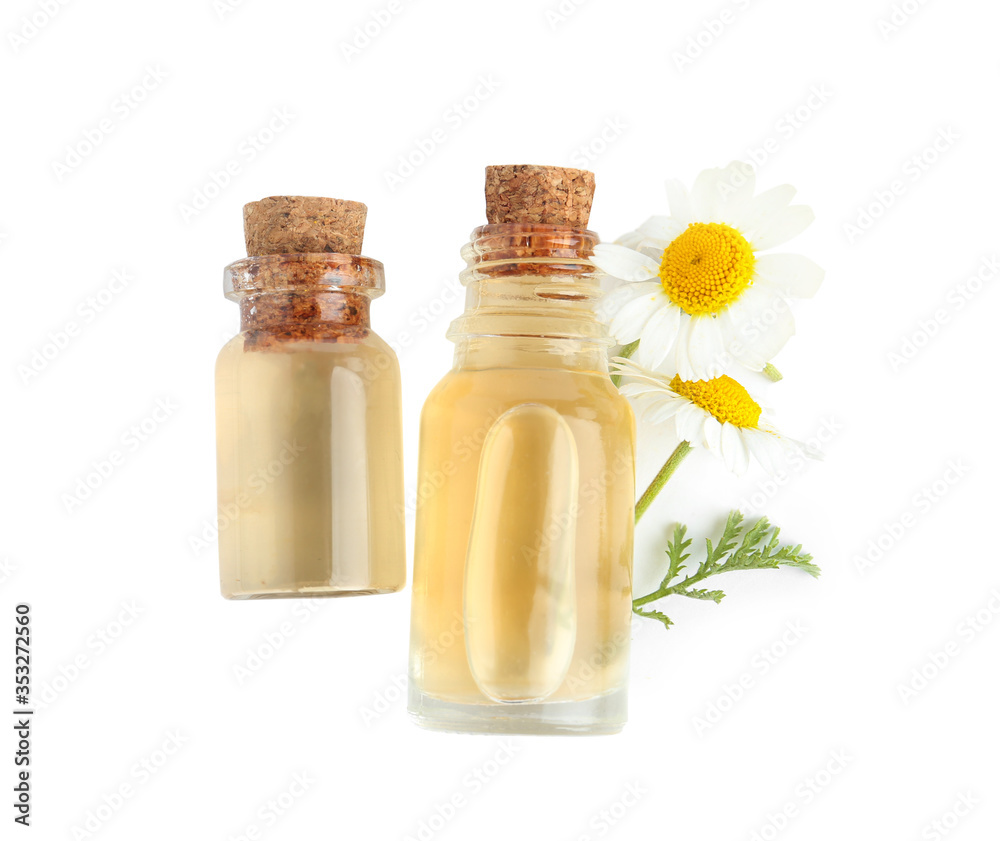 Bottles of essential oil and chamomiles isolated on white, top view Bottles of essential oil and chamomiles isolated on white, top view