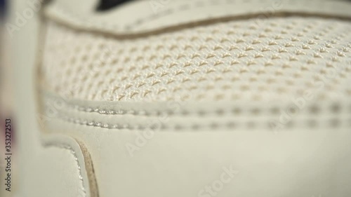 Extreme close up footage of perfect toe sneaker dolly in. Beige color. photo