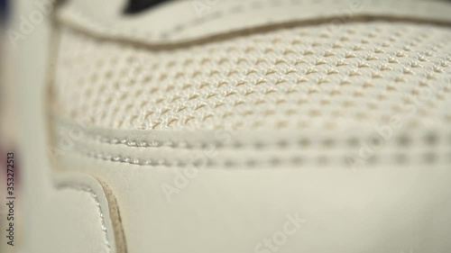 Extreme close up footage of perfect toe sneaker dolly in. Beige color.