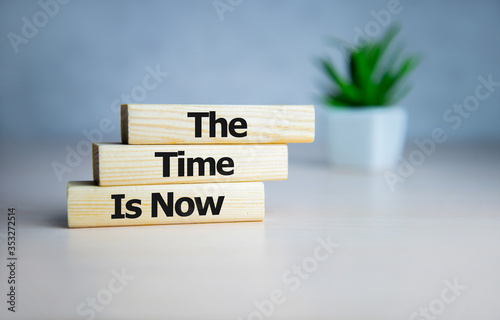 The time is now - words from wooden blocks with letters, the time is now concept, top background.