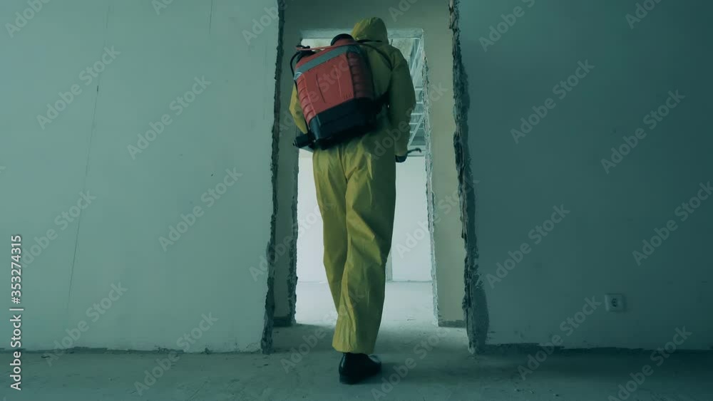 Man in hazmat sanitizes unfinished building to kill virus. Man in hazmat sanitizes unfinished building to kill virus.