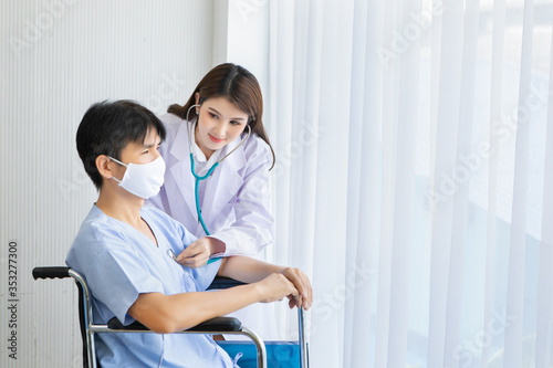 Doctor woman is taking care of sick patient young man with in hospital