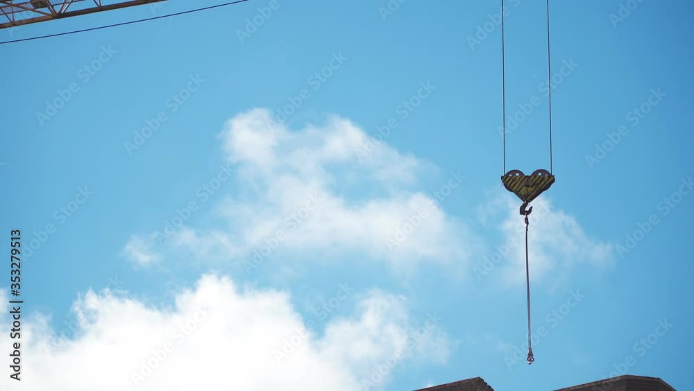 The work of a construction crane. Building on sky background. Close up The work of a construction crane. Building on sky background. Close up