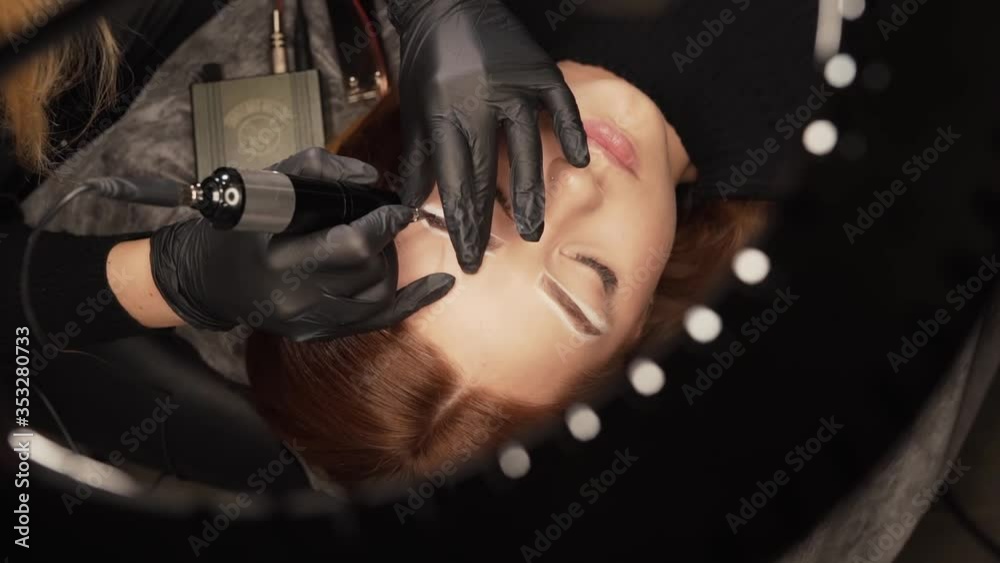 close-up portrait of a master's hand doing eyelash extensions to a young girl