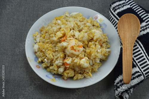 Famous luxury fried cooked jasmine rice with peeled fresh shrimp, crab meat and chicken egg on the plate. Traditional street food in Asia restaurant. Ancient menu in party. 