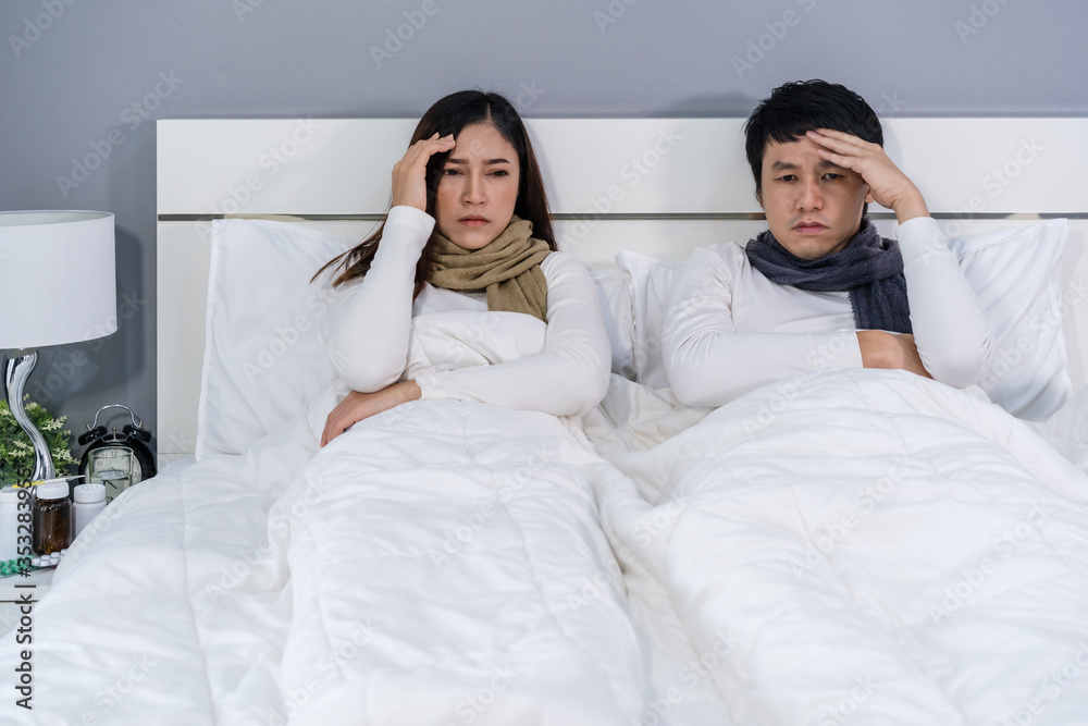 Fototapeta premium sick couple headache and suffering from virus disease and fever on bed