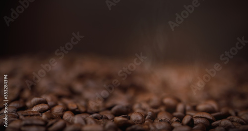 The hot of brown roasted coffee beans on brown background long banner with copyspace, Healthy products by organic natural ingredients concept