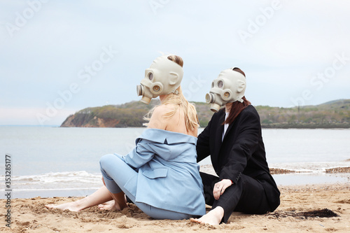 Girls in gas masks on the beach. 
Quarantine summer 2020. photo