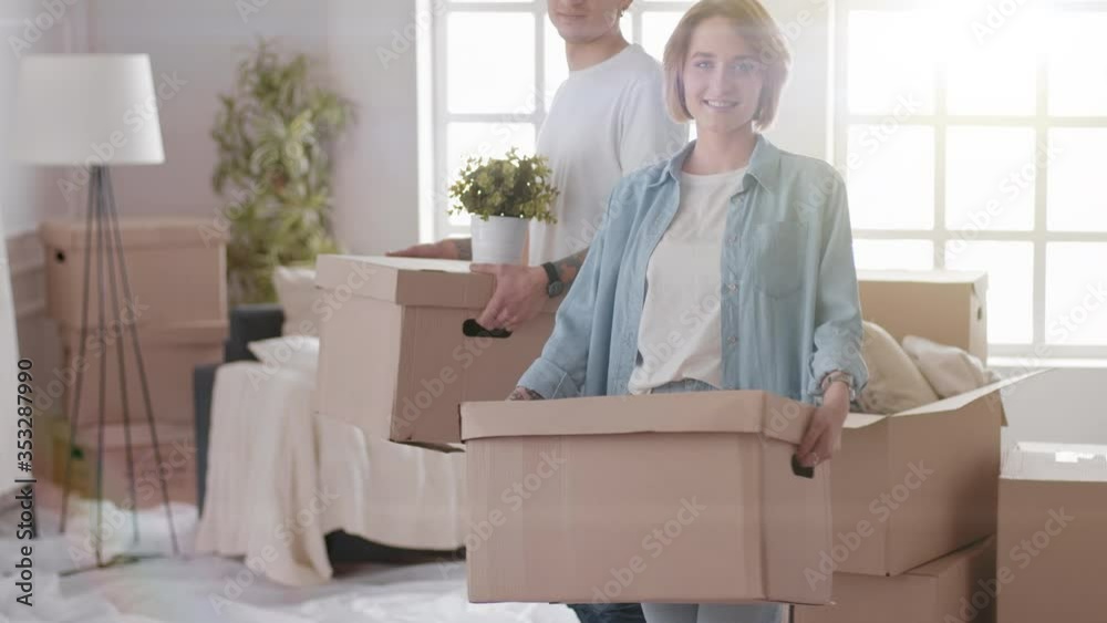 Excited Young Couple Unpacking Things, Opening Box And putting Excited Young Couple Unpacking Things, Opening Box And putting