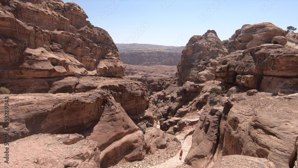 People hiking through the valleys of Petra in Jordan People hiking through the valleys of Petra in Jordan