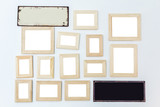 Multiple many blank small picture frames made of wood on white wall