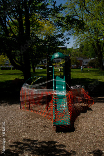 Safety fence and caution tape encompass a park jungle gym by order of New Jersey state mandates in response to the Covid-19 pandemic.