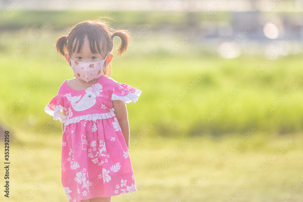 Little asian girl wear protect mask for children stand on the garden for virus protection. Little asian girl wear protect mask for children stand on the garden for virus protection.