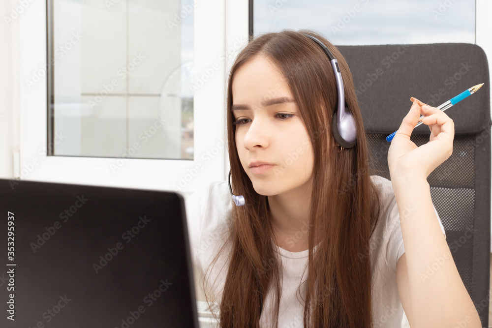 Girl in headphones with a microphone in front of a laptop Girl in headphones with a microphone in front of a laptop