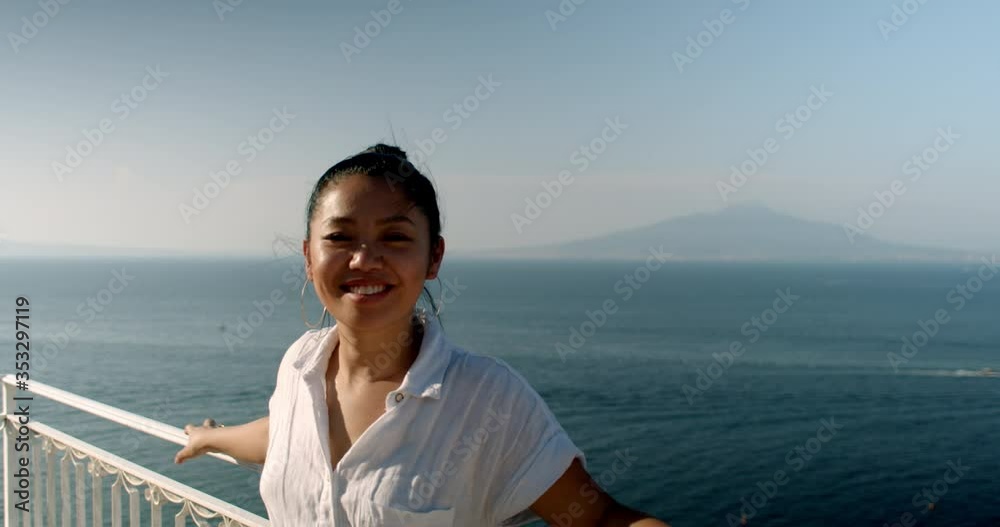 Portrait of young woman taking in beautiful view in Italy of the Amalfi coast in Positano Italy turning and smiling happy to be travelling abroad Portrait of young woman taking in beautiful view in Italy of the Amalfi coast in Positano Italy turning and smiling happy to be travelling abroad
