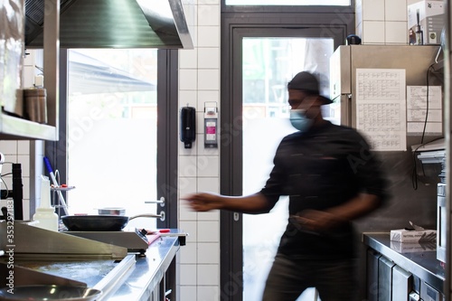 restaurant worker with mask working in kitchen