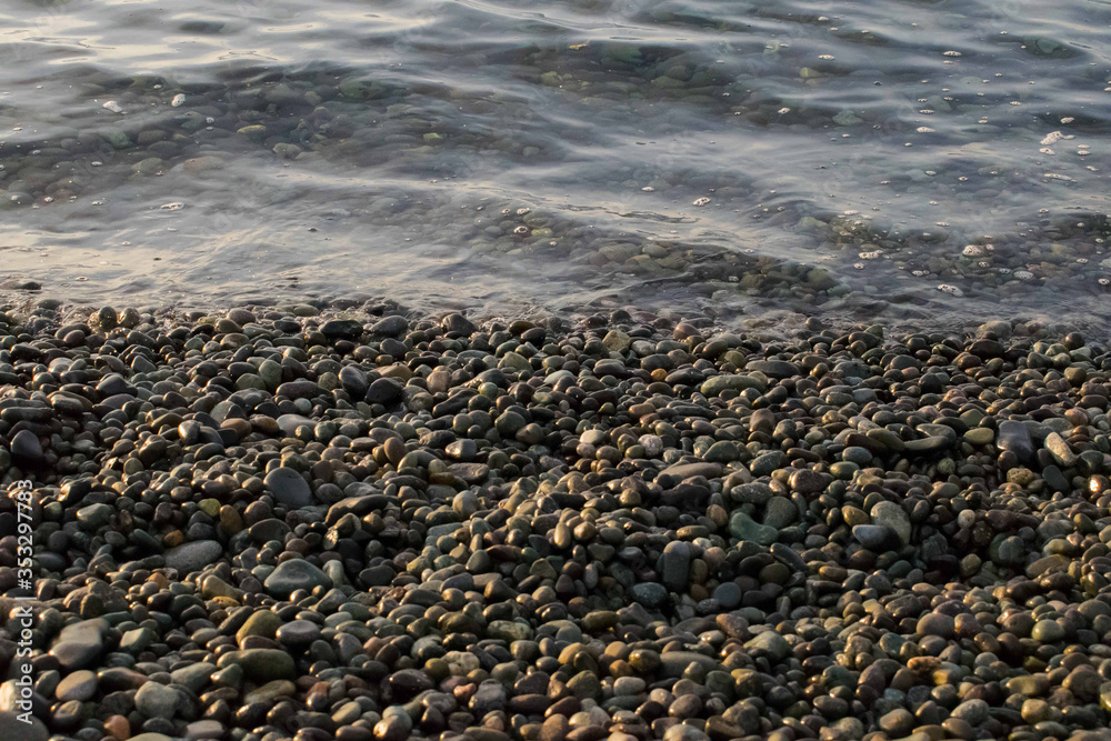 pebble stones by the sea. Silky waves of blue sea from long exposure. pebble stones by the sea. Silky waves of blue sea from long exposure.
