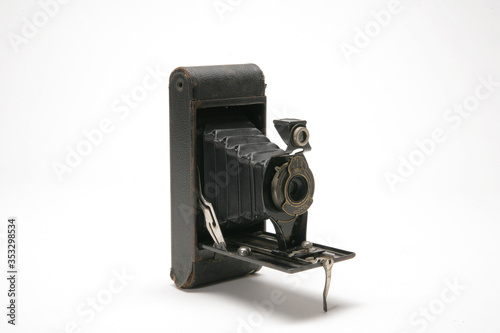 Vintage handheld medium format film camera with black leather bellows, three-quarters view to the right