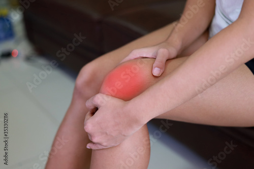 woman has pain in her knees. She is massaging to relieve the pain.