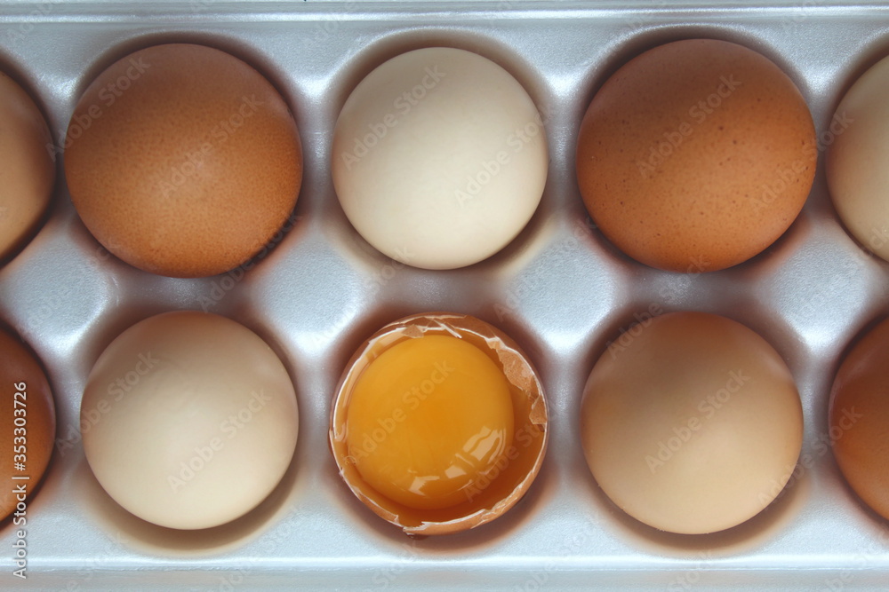 A tray of eggs with one half with a yellow yolk A tray of eggs with one half with a yellow yolk