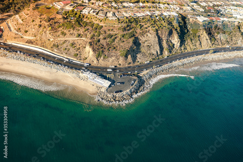 View from a helicopter cockpit flying over California  Malibu. Spectacular view of ocean  curve road  mountains.