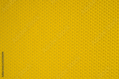 Synthetic yellow perforated stretch fabric, photographed close-up.