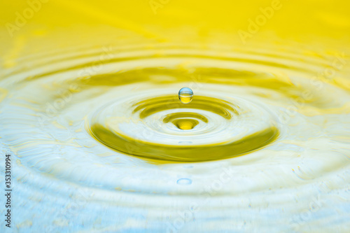 water drop splash on color gradient bright yellow surface macro