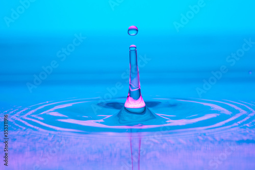 water drop splash on color gradient blue violet surface macro