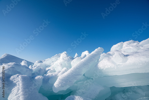 Closeup ice that covered with white snow. Water in the lake became frozen during winter period. Lake Baikal, Russia