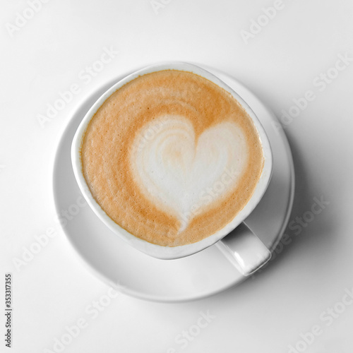 White cup of coffee with a heart made of milk foam.