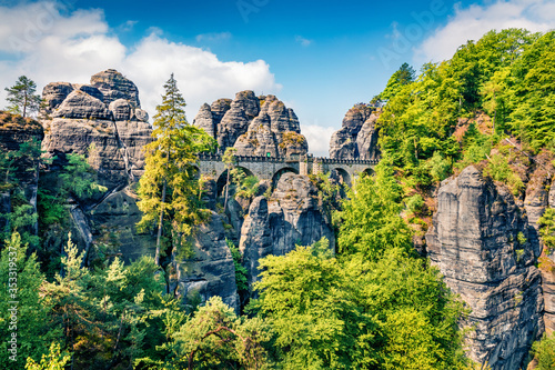 Sunny morning scene of sandstone cliff in Saxon Switzerland National Park with Bastei bridge on background. Colorful spring view of Germany  Saxony  Europe. Traveling concept background..